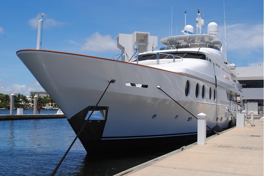 A huge luxurious yacht parked with in the sea.