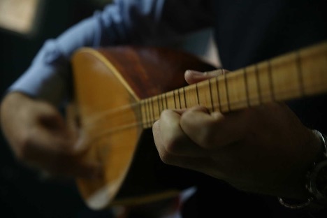 Man playing a 7-string saz instrument