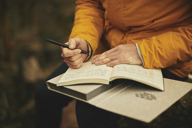 Woman writing in a dairy.