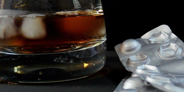 Alcohol with ice in the glass and tablets.