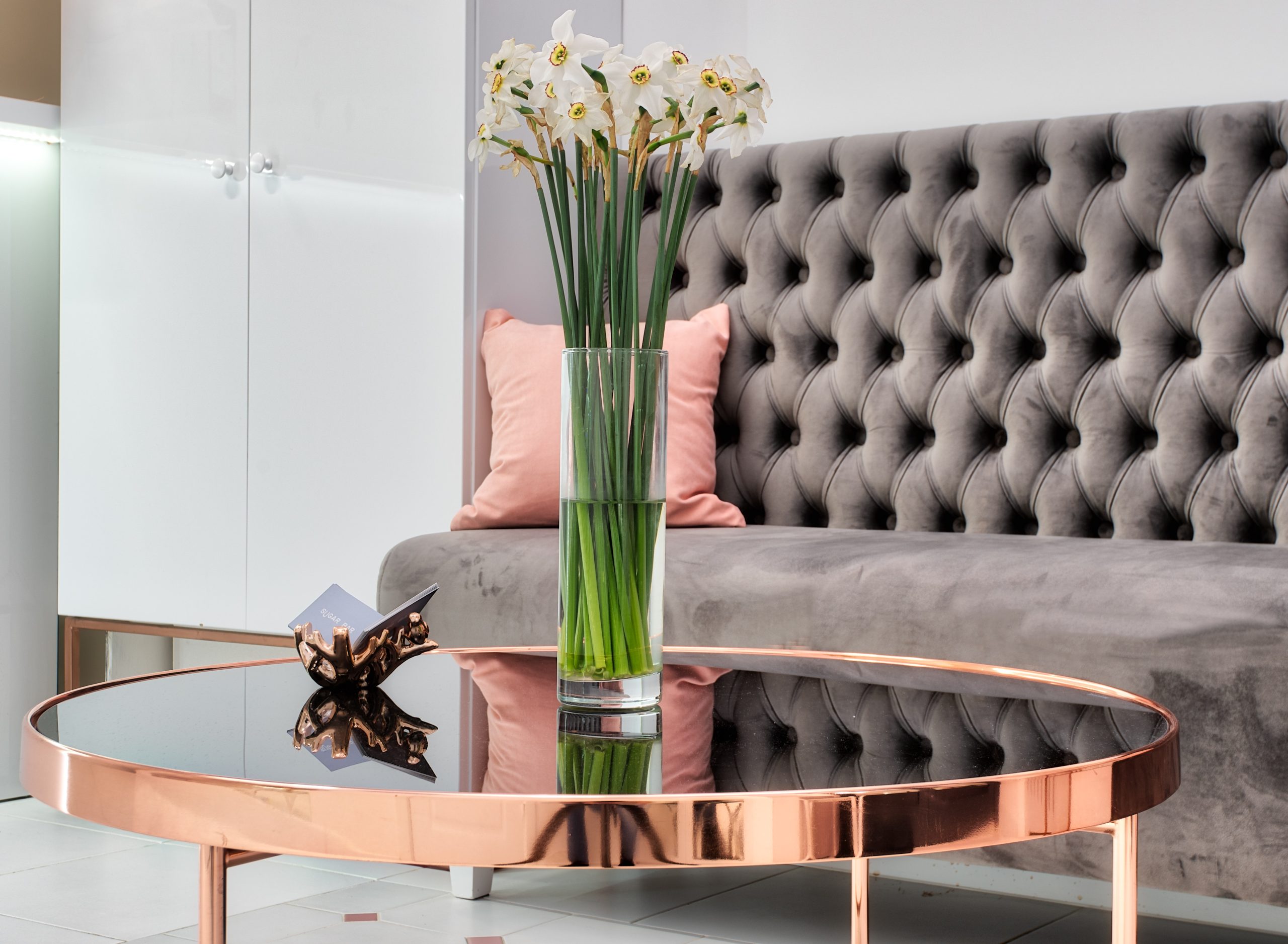 An office with a beautiful sofa, centre table and a cupboard.