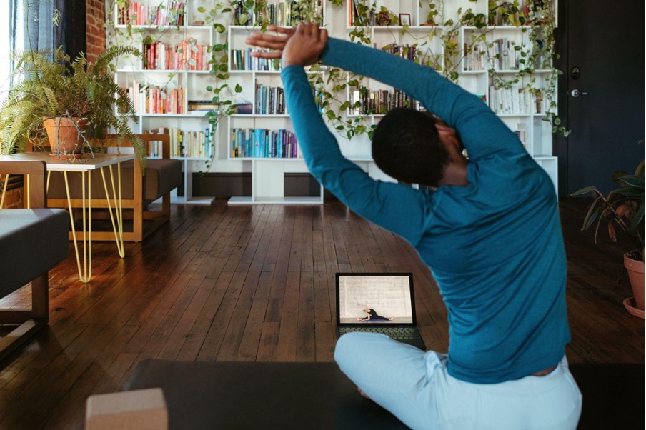 A woman doing online yoga in her house.