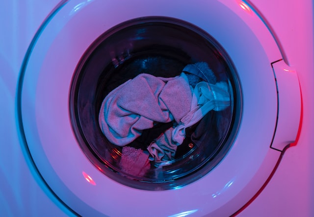 The clothes getting washed in the washing machine.