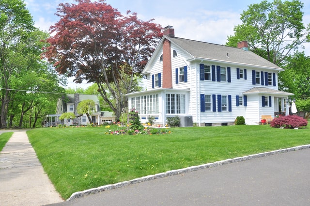 A beautiful house with lush green grass and trees.