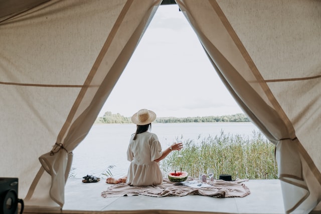 A woman sitting outside the tent and enjoying the view.