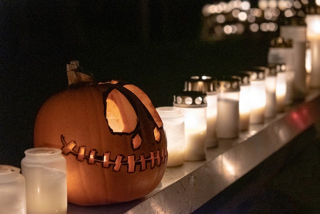 A halloween pumpkin with candles around.