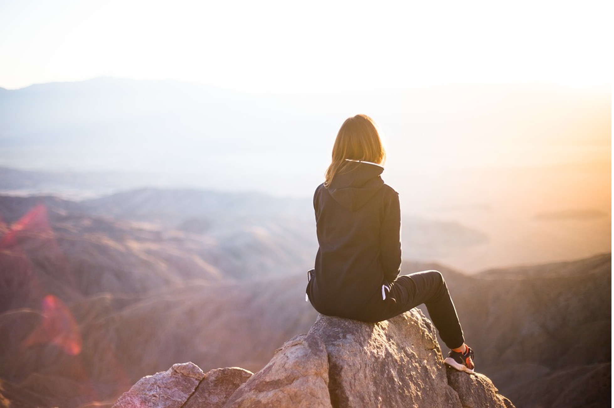 A woman sitting on the rocks and enjoying the beauty.