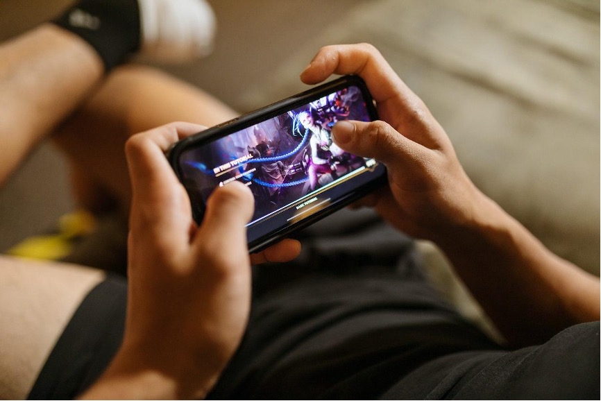 A boy playing a game on his smatphone.