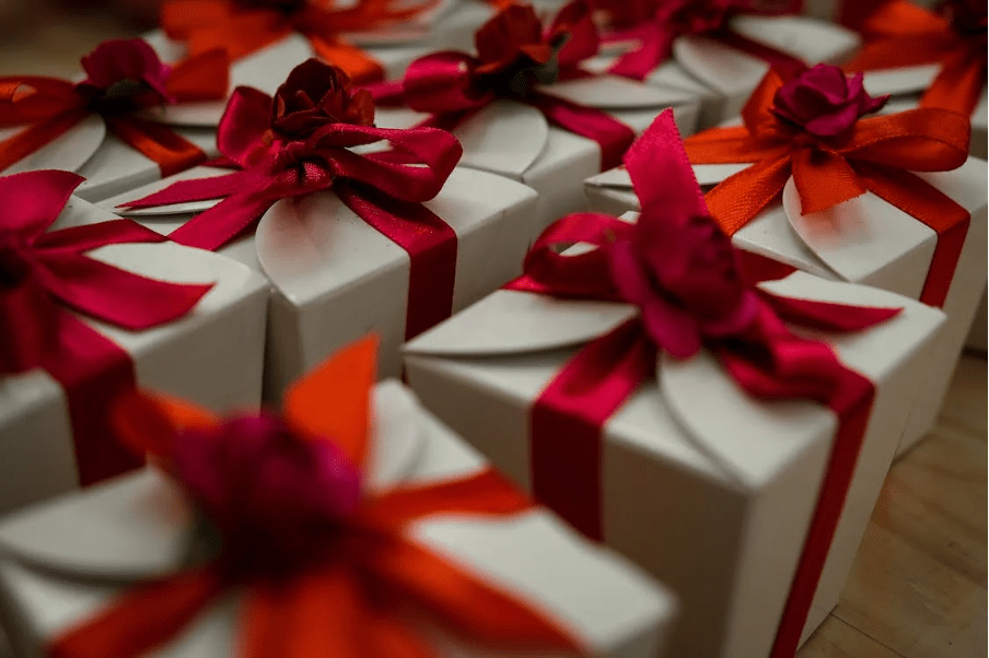 Gifts beautifully wrapped in boxes with red ribbons.