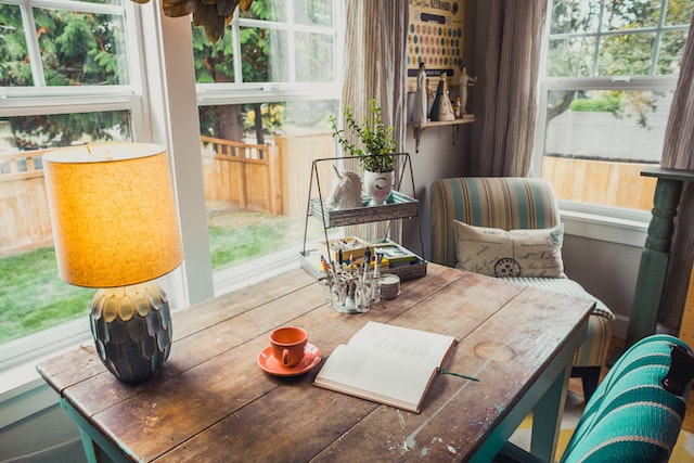 A room with a table, decoratives and lamp shade.