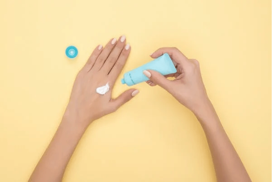 Woman applying cream on her hand.