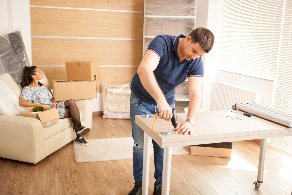 smiling-man-putting-together-self-assembly-furniture-new-home-furniture-new-house